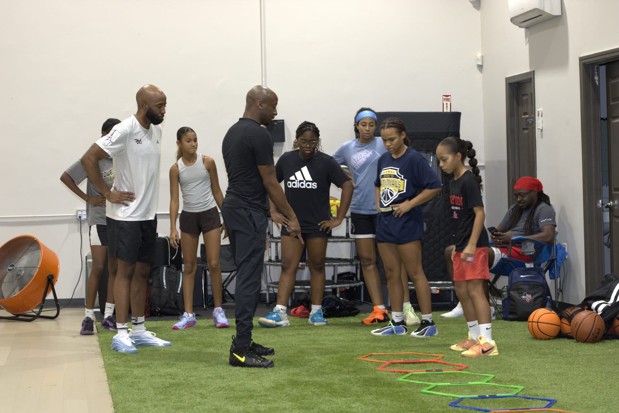 A coach working with the Girls Only group on the turf at Axis Sports Lab